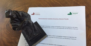 klein beeld van Erasmus op een document met overeenkomsten voor samenwerking tussen tussen de Stichting Erasmus Trustfonds en de Vereniging Erasmus Alumni Trust